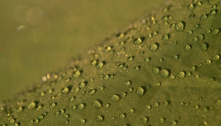Water droplets on waterproof fabric.Water drops on a green waterproof fabric close-up macro photography.Water drops on a waterproof fabric. ( Water droplets on the tent fabric.)	