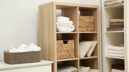 Home textile organization. Folded towels, blankets and pillows on shelving units indoors