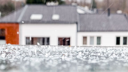 Rain and hail dropping on an attic window