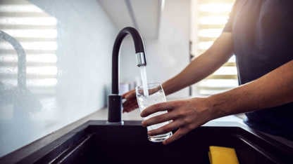 A person pouring water in a glass